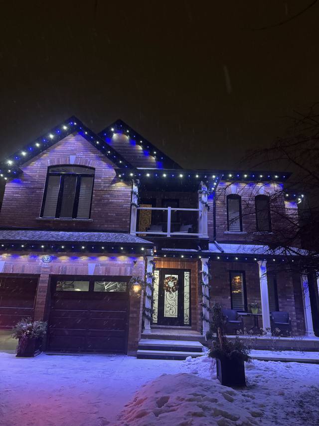 Home with blue permanent LED lighting during a snowfall