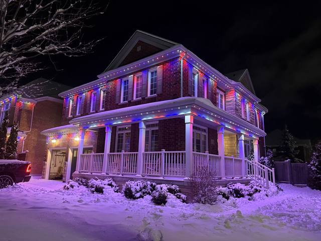 Home with multi-colour rainbow permanent LED lighting in the snow